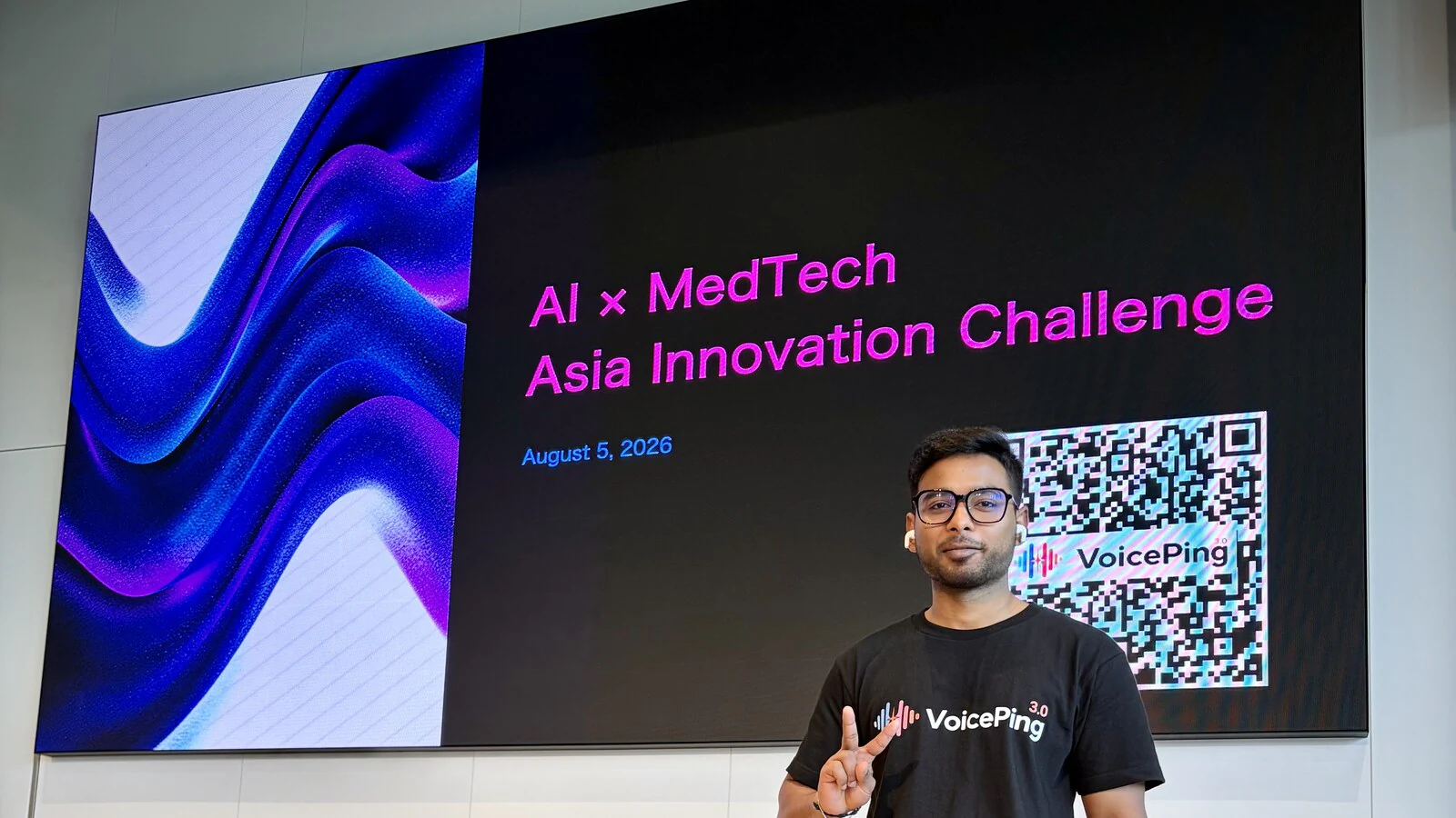 Akash from VoicePing in front of the AI×MedTech event display and attendee-access QR code.