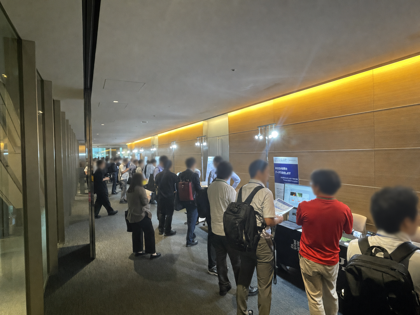 参会者在 Sony Open Innovation Day 2026 展览通道与展商交流，所有可识别的非舞台人物面部均已模糊处理。